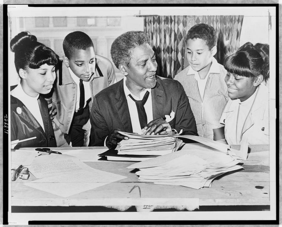 Bayard Rustin (center) speaking with (left to right) Carolyn Carter, Cecil Carter, Kurt Levister, and Kathy Ross, before demonstration