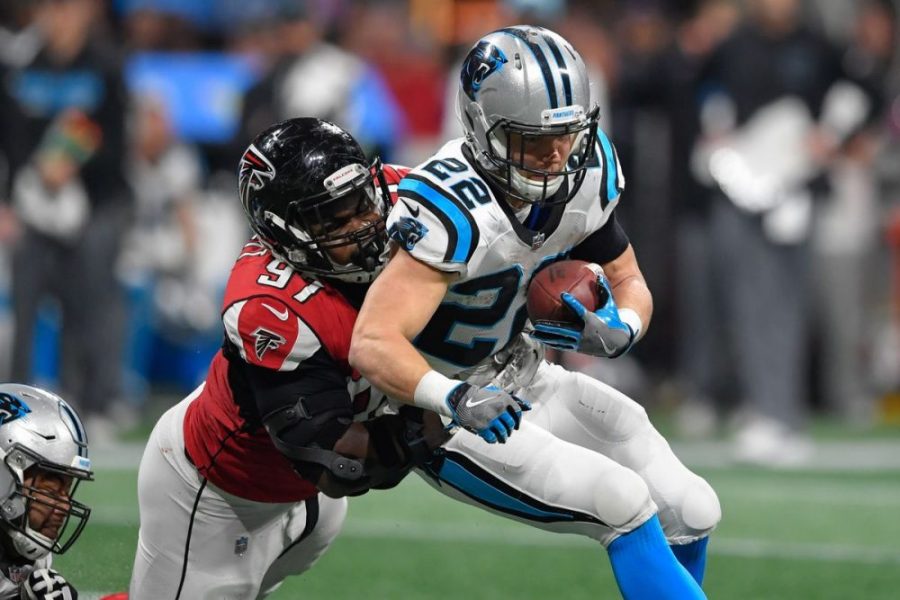 Current Panthers running back Christian McCaffrey attempting to break free from a Grady Jarrett tackle.