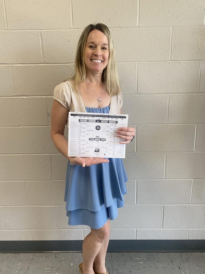 Mrs. Renee McMinn, the winner of the 2023 Falcon Flash March Madness competition, posing with her winning bracket. McMinn took home a McDonalds gift card as a prize for the victory.
